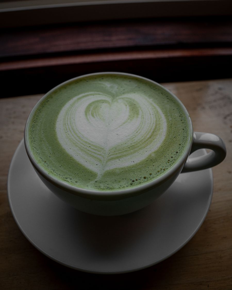 A matcha latte with a heart poured in the foam