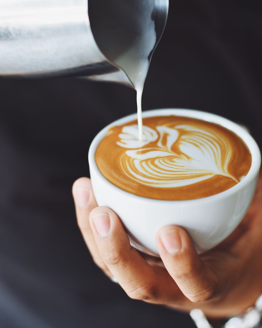 Milk being poured into a cappuccino, forming a rosetta