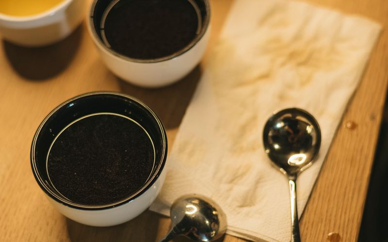 Cupping bowls and spoons lined up on a wooden table
