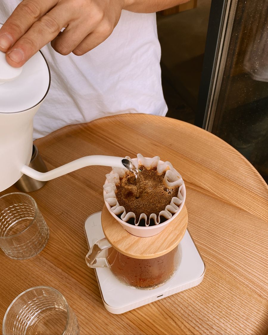 A pour-over being brewed by hand into a glass carafe